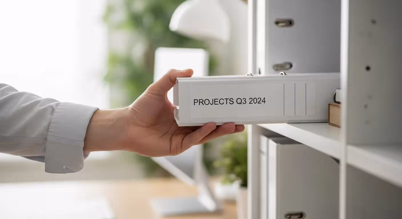 A hand retrieves a grab-and-go binder from a shelf.