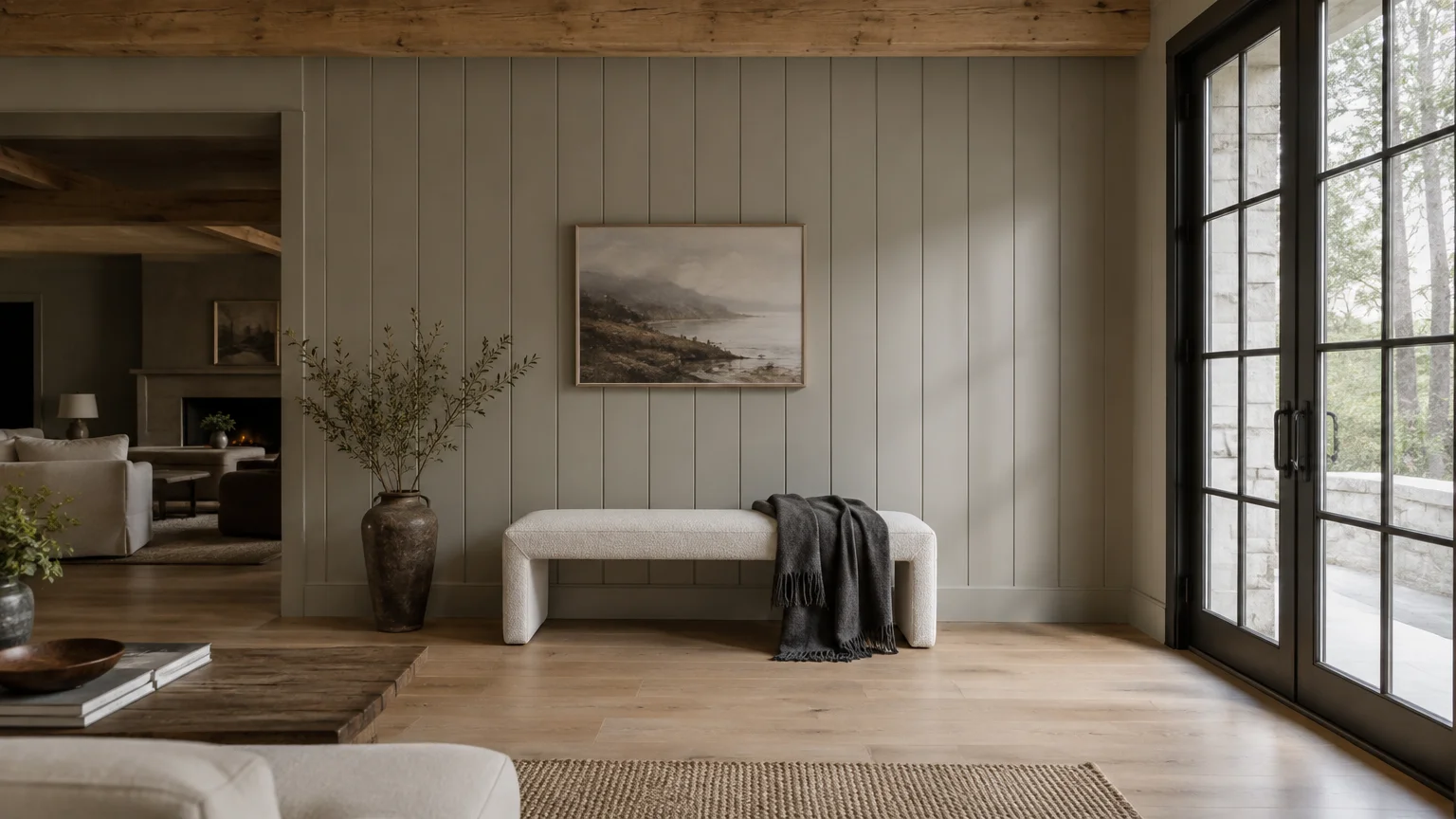 Greige vertical shiplap wall with framed art, an upholstered bench, glass patio doors, and light wood flooring.